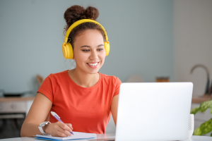 Woman using laptop with headphones.