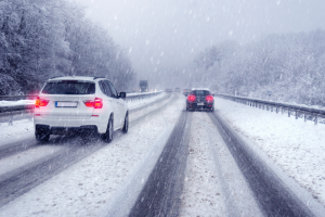 Cars on road covered in snow.