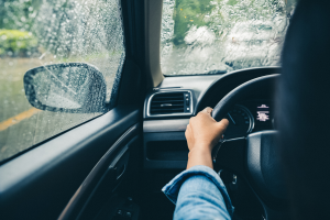 View from the back of the front seat of driver in car. Driving on rainy day.