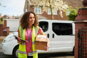 Woman with yellow vest is delivering cardboard box. 