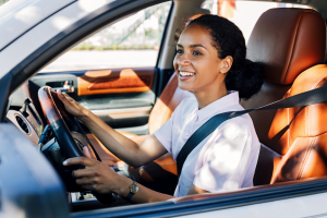 Woman driving car and smiling.