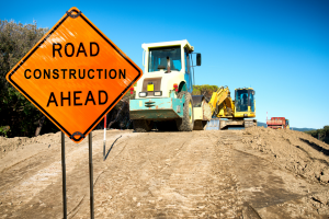Road machinery, fixing road with road construction sign.