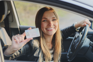 Woman smiling and holding drivers license.