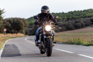 Man driving motorcycle on paved road.