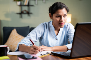 Woman using laptop while receving course online.